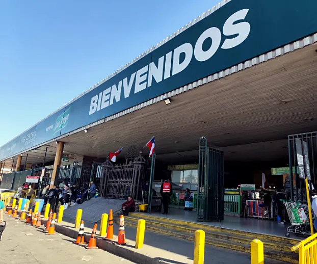 Acceso principal de la Vega con letrero Bienvenidos y guardia de seguridad